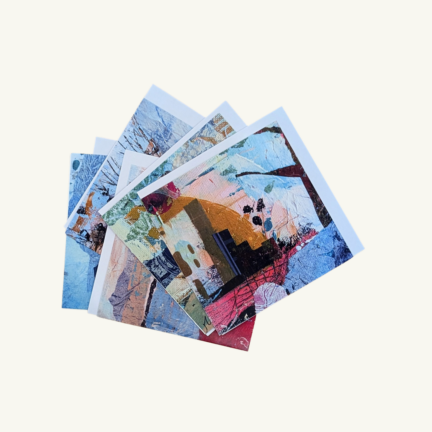 Stack of colorful greeting cards depicting abstract city and country scenes on a white background created by Jen Rodger 