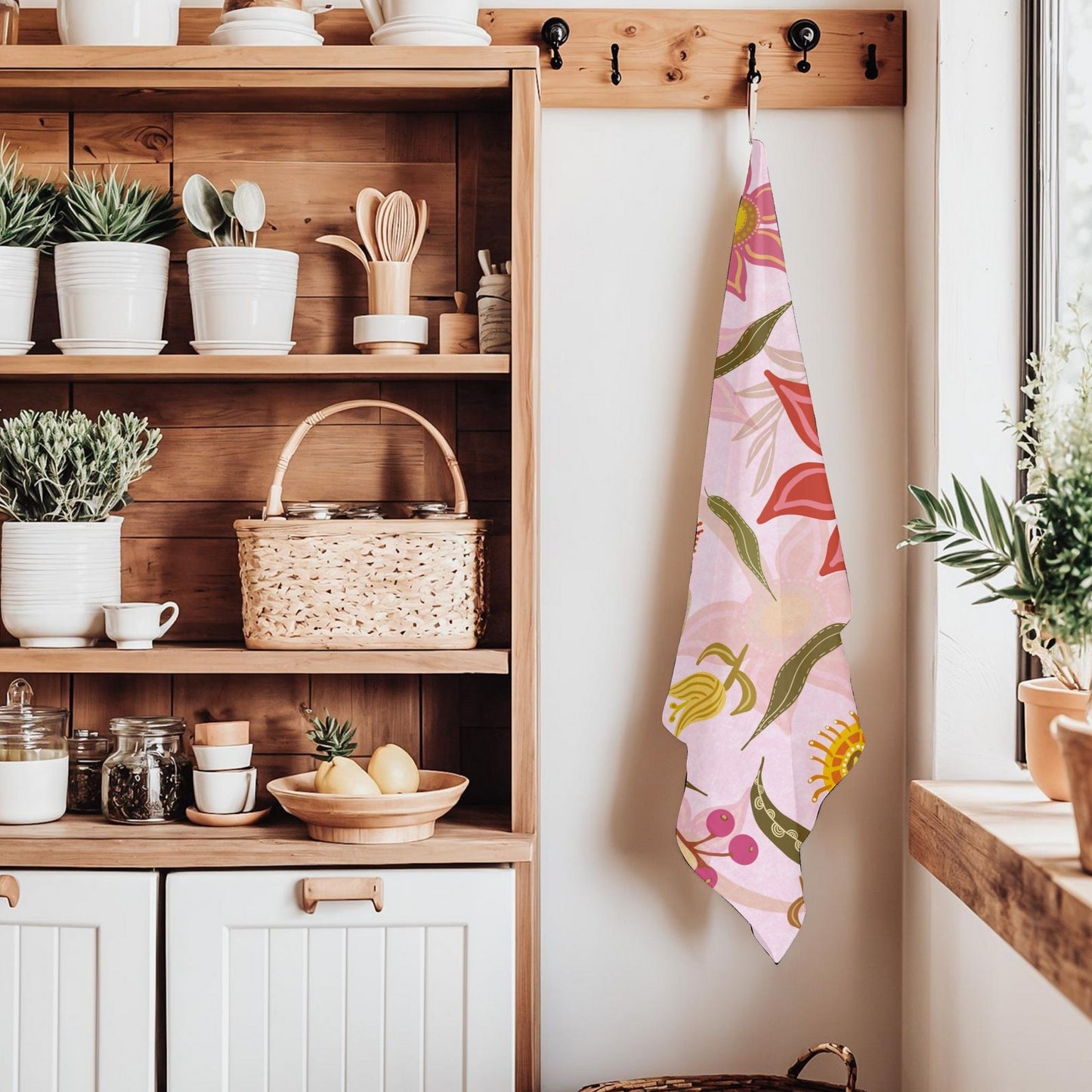 Kitchen interior with wooden shelves, plants, and a floral tea towel in a Jen Rodger design Gum Flower Magic.